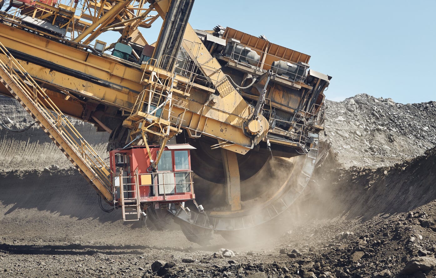 Image shows a large mining machine in operation at a surface mine, showcasing the mining and heavy machinery key industries.