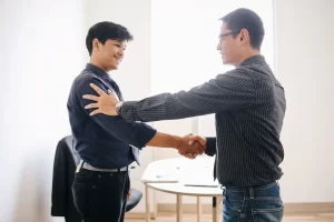 The picture is shoing 2 males greeting each other as what appears to be a business meeting.